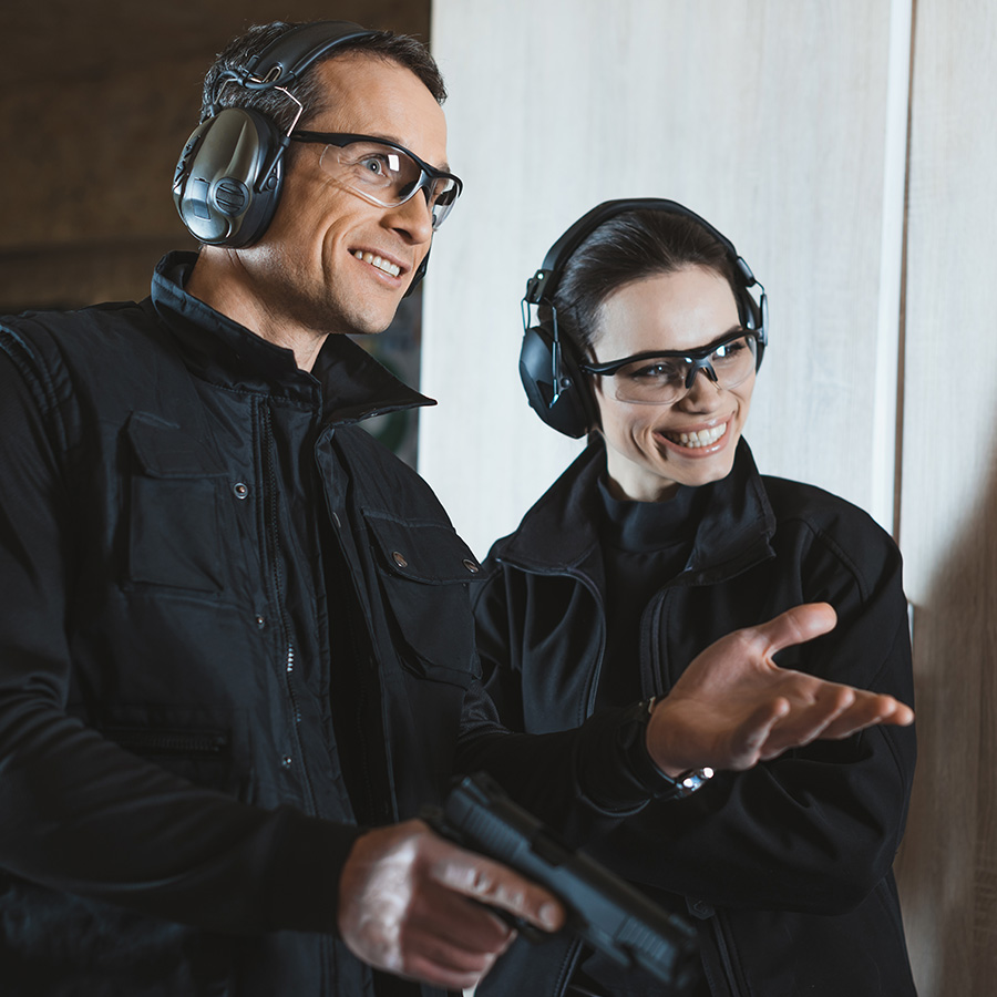 HOME 3 smiling shooting instructor and customer in shooti DQQ2E9E
